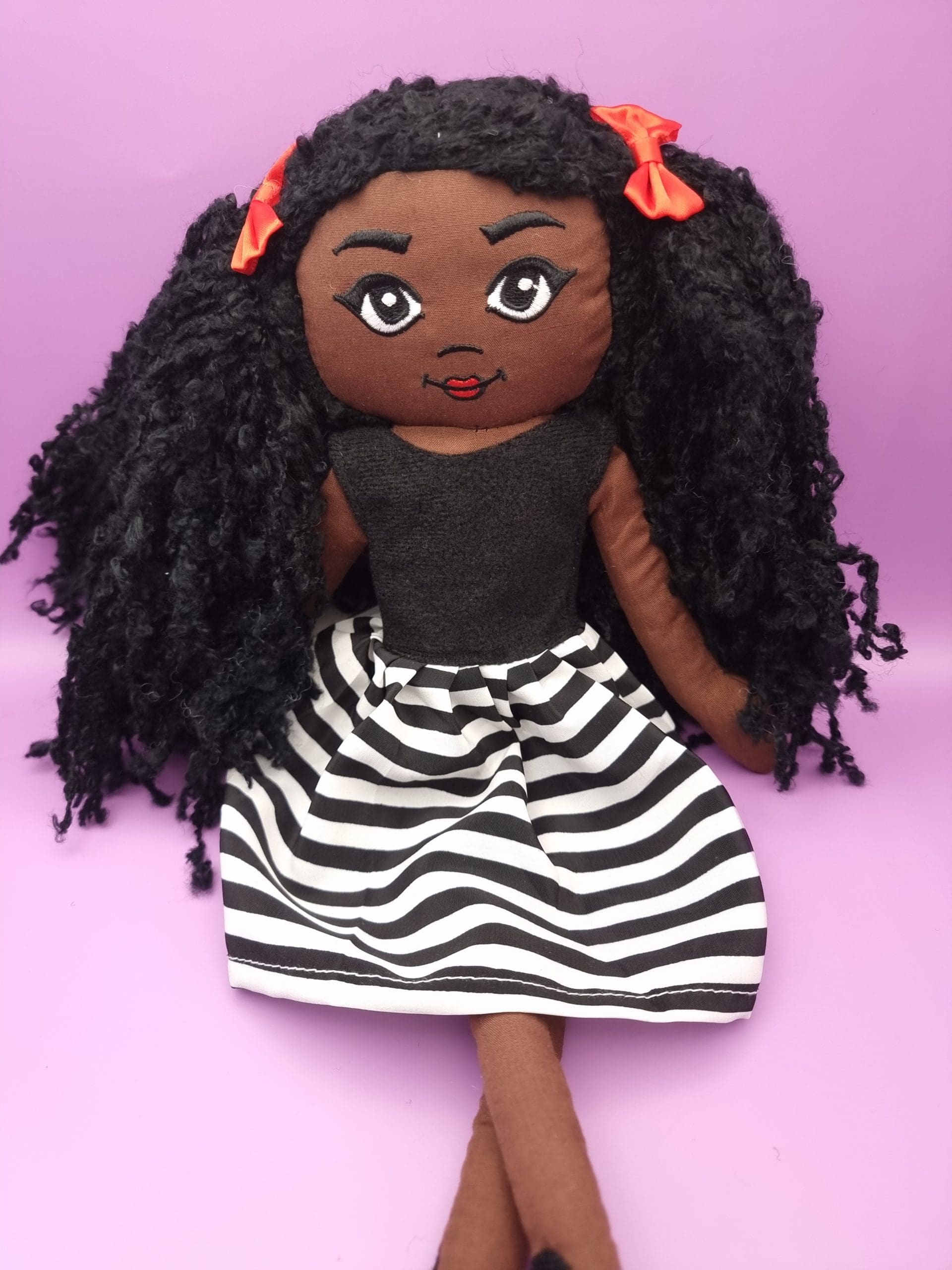 Amaris Handmade black girl fabric doll wearing a black dress with a black and white skirt