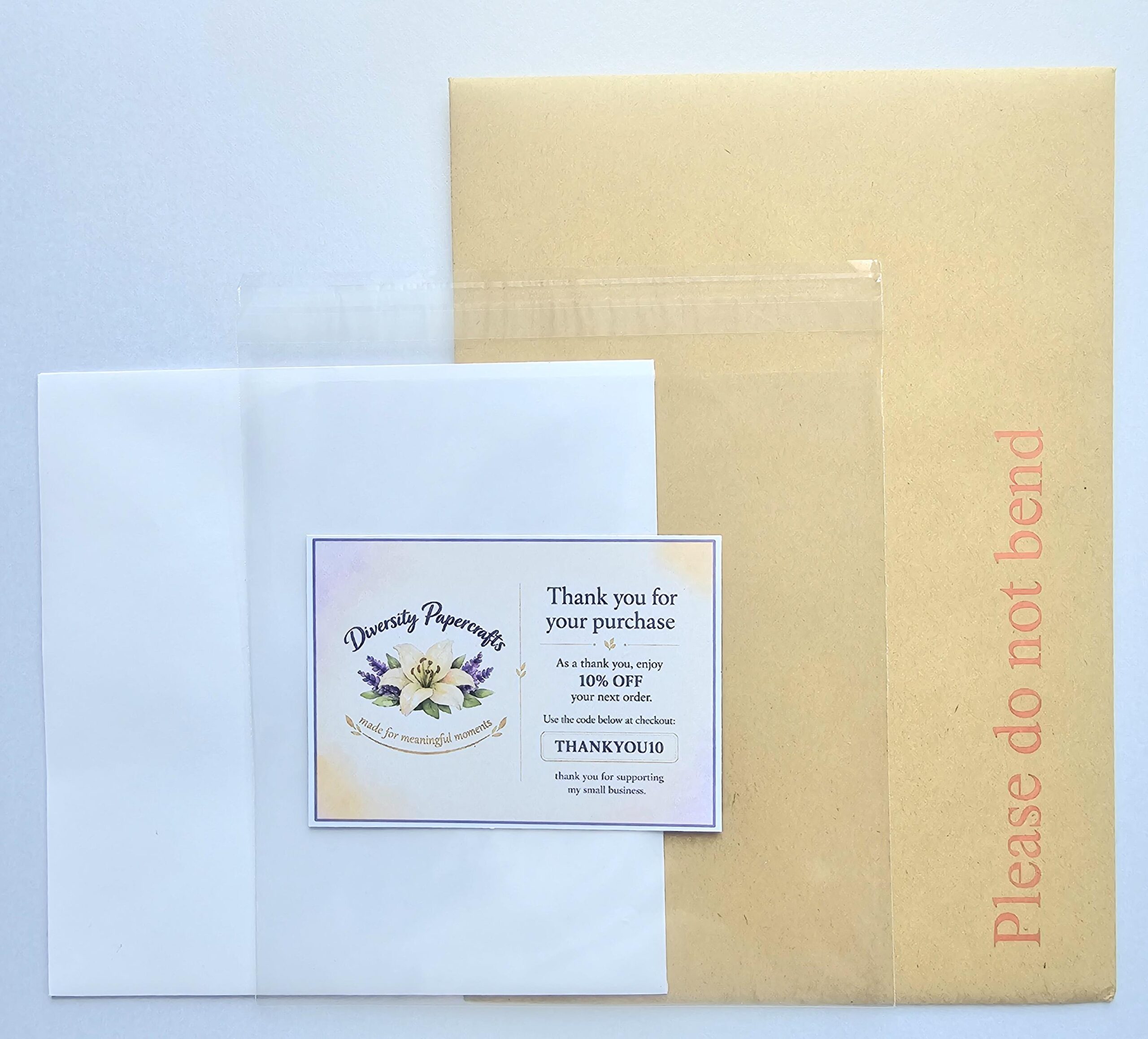 Generic packaging shot Greeting card packaging with protective cello bag, thank-you sticker, voucher and rigid postal mailer.